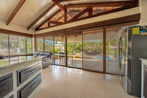 Una cocina moderna con comedor, ventanas amplias y vistas al exterior.