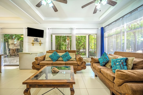 A spacious living room with two sofas, a coffee table, and a ceiling fan. - Playa Carrillo: Private Pool, 1 Mi to Beach (Playa Carrillo)