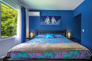 A bedroom with a bed, two bedside tables, a wall-mounted air conditioner, and a window with curtains. - Playa Carrillo: Private Pool, 1 Mi to Beach (Playa Carrillo)