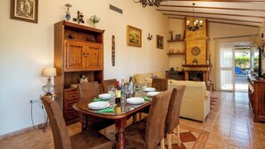 A dining area with a round table set for four, surrounded by chairs. - Villa La Guirnalda Alhaurín el Grande by Ruralidays (Málaga)
