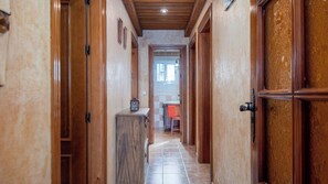 Ein Korridor mit Holztüren und Fliesenboden, der zu einem Badezimmer führt.