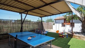 An outdoor covered area with a ping pong table, a children's play table, and a swing set. - Villa La Guirnalda Alhaurín el Grande by Ruralidays (Málaga)