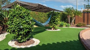 A garden with artificial grass, a hammock, and various plants. - Villa La Guirnalda Alhaurín el Grande by Ruralidays (Málaga)