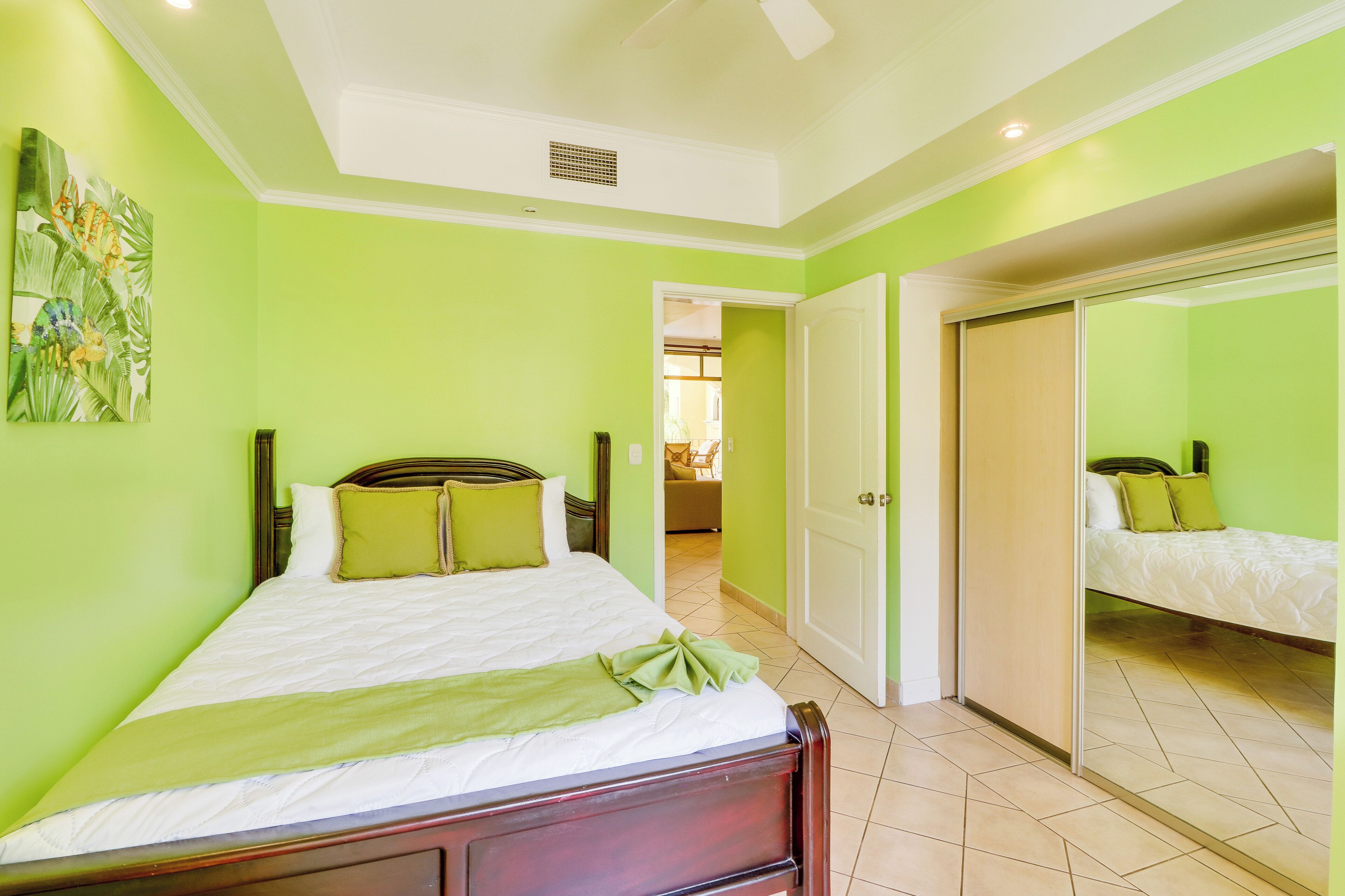 Una habitación con una cama, una puerta y un pasillo que lleva a otra habitación.