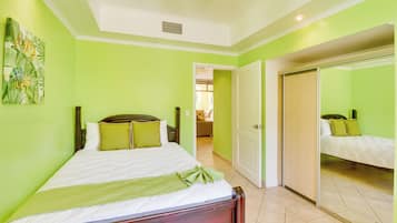 Una habitación con una cama, una puerta y un pasillo que lleva a otra habitación.