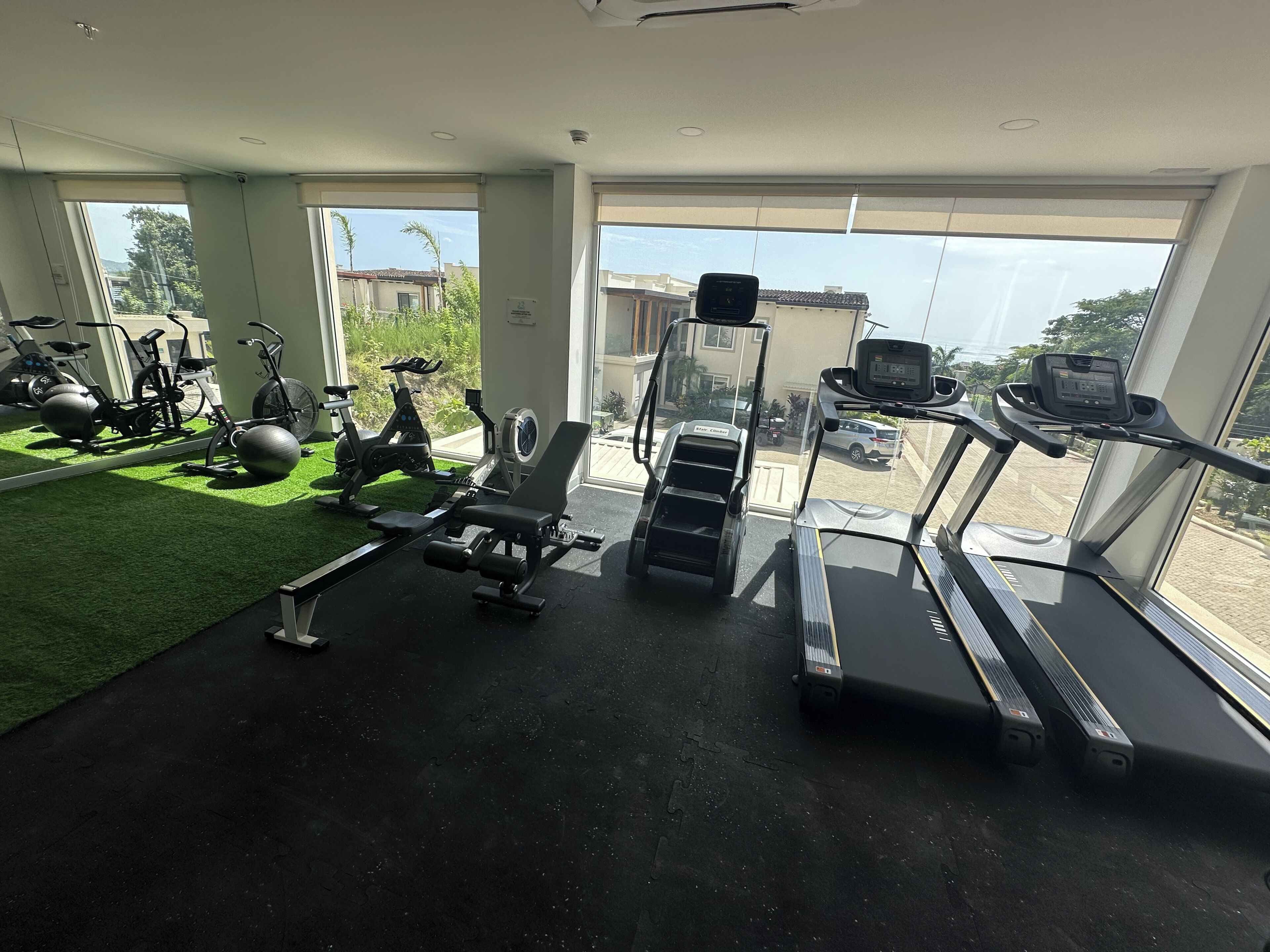 Ginásio com esteiras, bicicletas ergométricas e bolas de exercício.