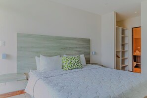 A bedroom with a bed, a headboard, a wardrobe, and a bedside table.