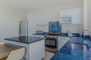 A modern kitchen with a built-in oven, a microwave, and a toaster. - Puerto Azul Marina, Pool & On-Site Dining (El Roble)