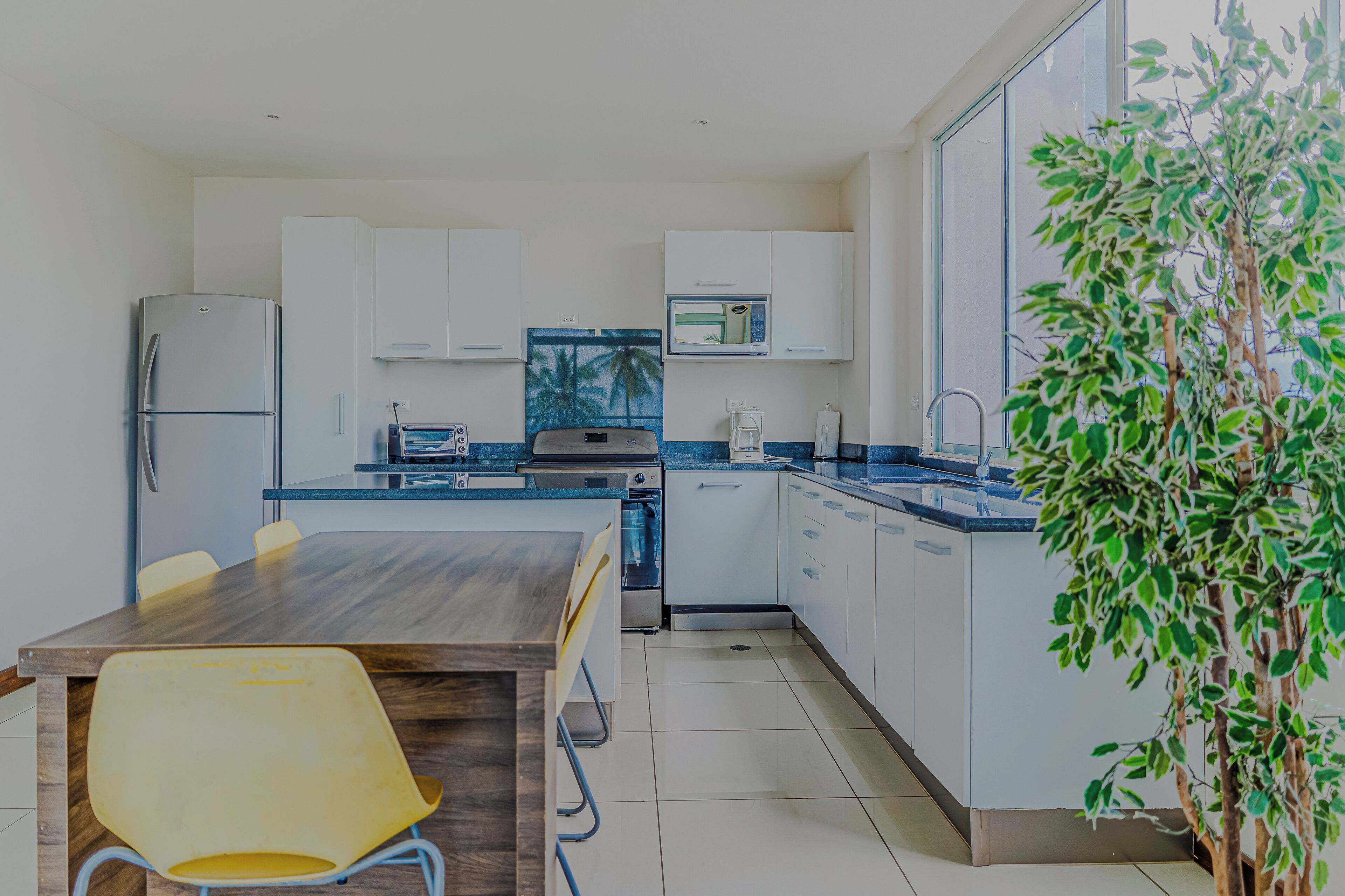 A modern kitchen with white cabinets, a microwave, and a coffee maker.