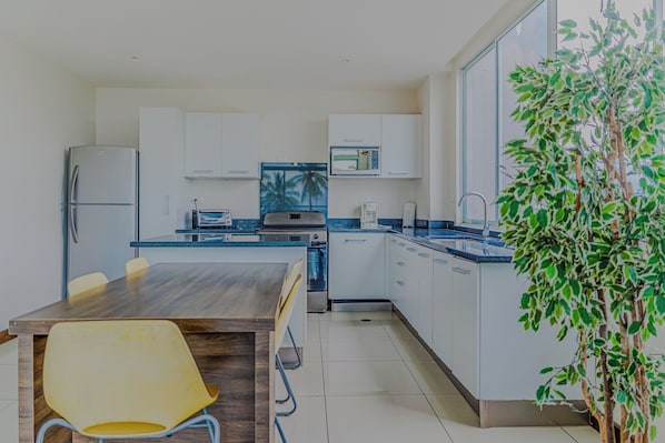 A modern kitchen with white cabinets, a microwave, and a coffee maker.