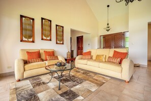 A living room with two sofas, a coffee table, and a rug. - Stunning Lake Arenal Views: Duplex Unit w/ Patio! (La Fortuna)
