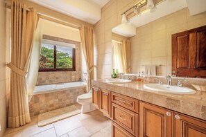A bathroom with a bathtub, two sinks, a toilet, and a window with curtains. - Stunning Lake Arenal Views: Duplex Unit w/ Patio! (La Fortuna)