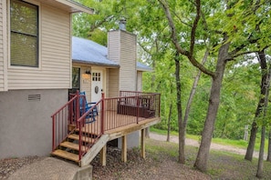 A two-story house with a wooden deck, a front door, and a mailbox. - Bigfoot’s Bunk: Cozy Cabin on Table Rock Lake (Kimberling City)