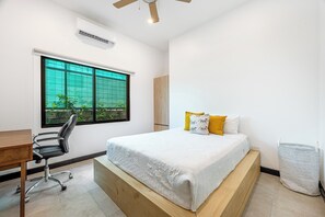 A bedroom with a bed, a desk, a chair, a window, and a ceiling fan. - Walk to Beach! Tamarindo Home w/ Private Pool (Tamarindo)