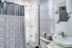 A bathroom with a shower curtain, a sink, and a mirror. - Pool & Entertaining Patio: Playa Carrillo Home (Playa Carrillo)