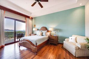 A bedroom with a bed, bedside tables, a nightstand, a chair, a balcony with a view, and a ceiling fan. - Playa Hermosa Penthouse: Ocean Views, 2 Pools (Playa Hermosa)