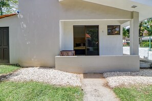 A modern building with a flat facade, a small porch area with a bench, and a door leading to an interior space. - 3-Unit Bundle: Club Voca Pool Access, Near Beach! (Playas del Coco)