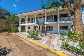 A two-story building with a covered entrance and a staircase leading to the upper floor. - Playas del Coco Condo w/ Pool: Walk to Beach! (Playas del Coco)
