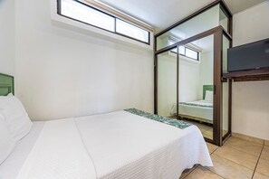 A hotel room with a bed, a television, a sliding glass door, and a window. - Playas del Coco Condo w/ Pool: Walk to Beach! (Playas del Coco)