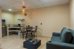 A compact living space with a kitchenette, a dining area with chairs, a sofa, and a coffee table. - Uvita Studio 2 Mi to Beach: Fast WiFi (Uvita)