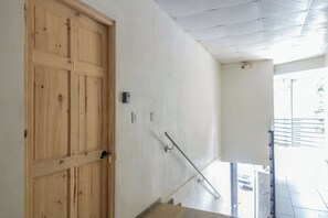 A wooden door with a number '1' indicating a room or section, a metal handrail, and a white wall with a ceiling. - Uvita Studio 2 Mi to Beach: Fast WiFi (Uvita)