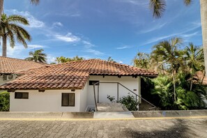 A residential building with a tiled roof, a small entrance, and a staircase leading to the door. - Pool & Beach Access: 2-Unit Base in Playa Hermana (Playa Hermosa)