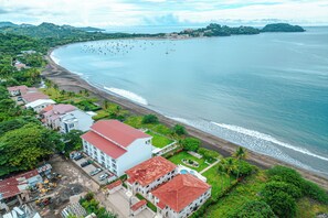 A coastal hotel with multiple buildings, a beach, and a marina. - Playa Potrero: 2 Balconies & Private Grill (Playa Potrero)