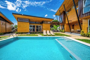 Een modern gebouw met een zwembad, een houten gevel en een overdekt terras.