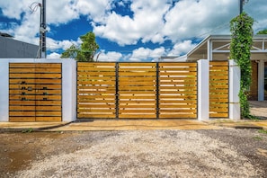 A gated entrance with a gravel driveway leading to a building with a white exterior and a covered porch. - 2 Studios w/ Pool Access < 1 Mi to Playas Del Coco (Playas del Coco)