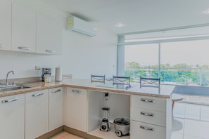 A modern kitchen with a built-in stove, a blender, and a coffee maker.