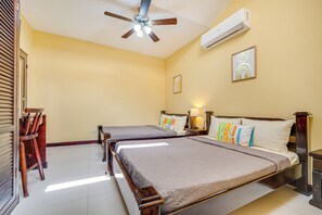 A hotel room with two beds, a ceiling fan, an air conditioning unit, and a wall-mounted artwork. - Family Retreat w/ Pool Access: Walk to Beach! (Playas del Coco)