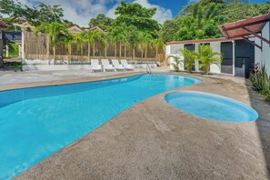 A swimming pool with a clear blue water surface, surrounded by a concrete deck and white lounge chairs. - Family Retreat w/ Pool Access: Walk to Beach! (Playas del Coco)