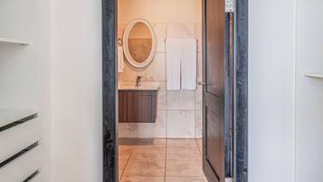 A bathroom with a sink, mirror, and towel rack.