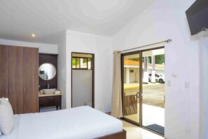 Une chambre à coucher avec un lit, une table de chevet, un miroir et une armoire.