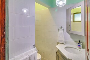 A bathroom with a toilet, sink, and mirror. - Playas del Coco Condo: Walk to Beach & Restaurants (Playas del Coco)