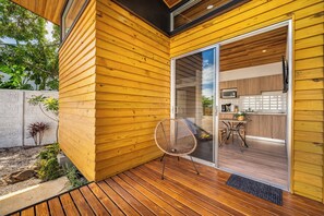 A modern wooden exterior with a sliding glass door leading to a kitchen area. - < 1 Mi to Playas del Coco: Studio w/ Pool Access! (Playas del Coco)
