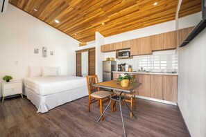 A compact living space with a bed, a dining table with chairs, a kitchenette, and a wooden ceiling. - < 1 Mi to Playas del Coco: Studio w/ Pool Access! (Playas del Coco)
