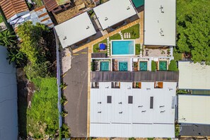 A residential area with multiple buildings, a swimming pool, and a paved driveway. - < 1 Mi to Playas del Coco: Studio w/ Pool Access! (Playas del Coco)