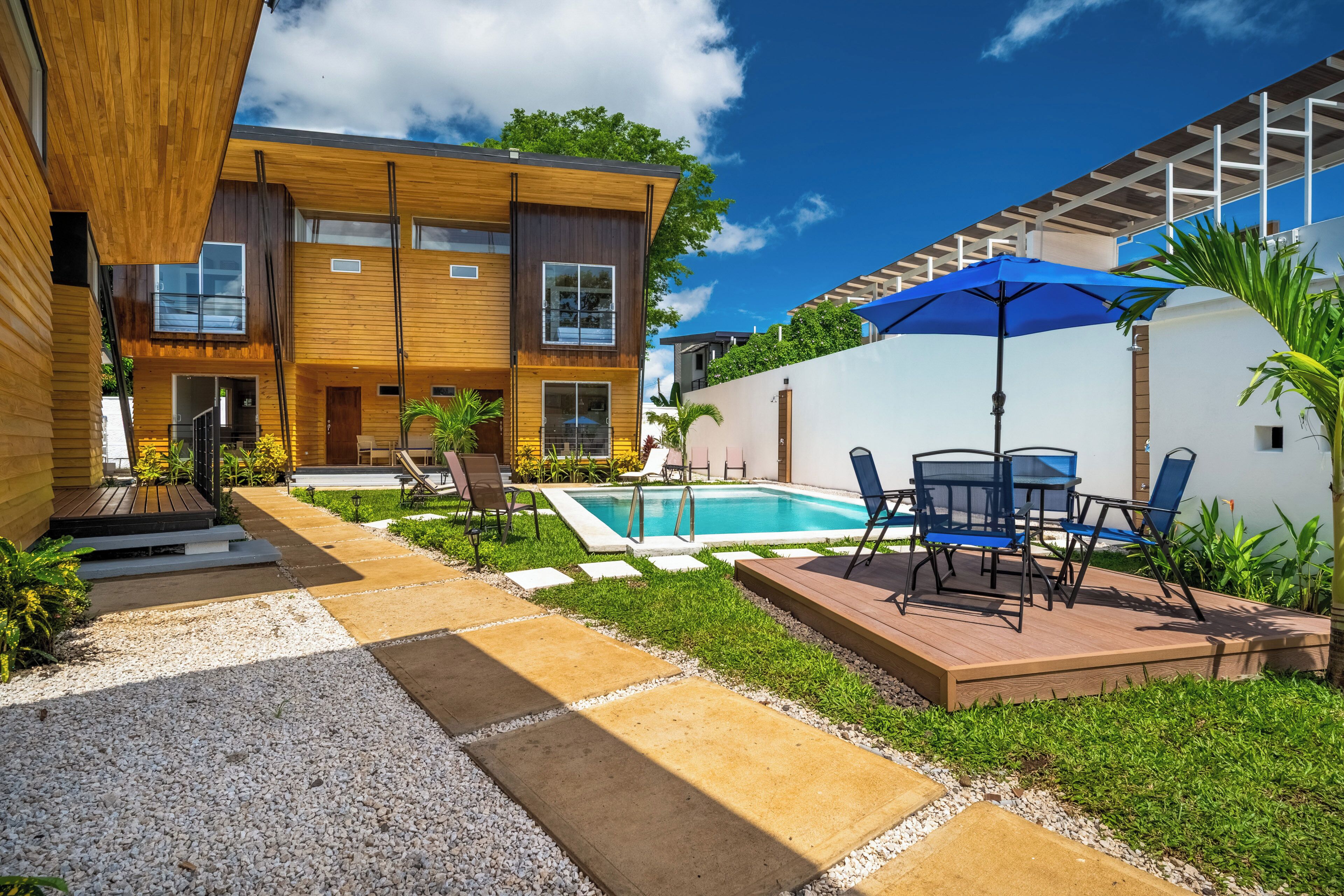 A modern house with a swimming pool, outdoor seating, and a well-maintained garden.