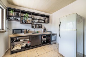 A compact kitchen with a built-in microwave, a refrigerator, and a sink. - Playas del Coco Condo w/ Pool: Walk to Beach! (Playas del Coco)