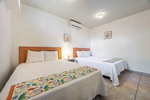 A hotel room with two beds, a nightstand with a lamp, and a ceiling fan. - Playas del Coco Condo w/ Pool: Walk to Beach! (Playas del Coco)