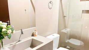 Ein Badezimmer mit Waschbecken, Spiegel, Toilette und Dusche.