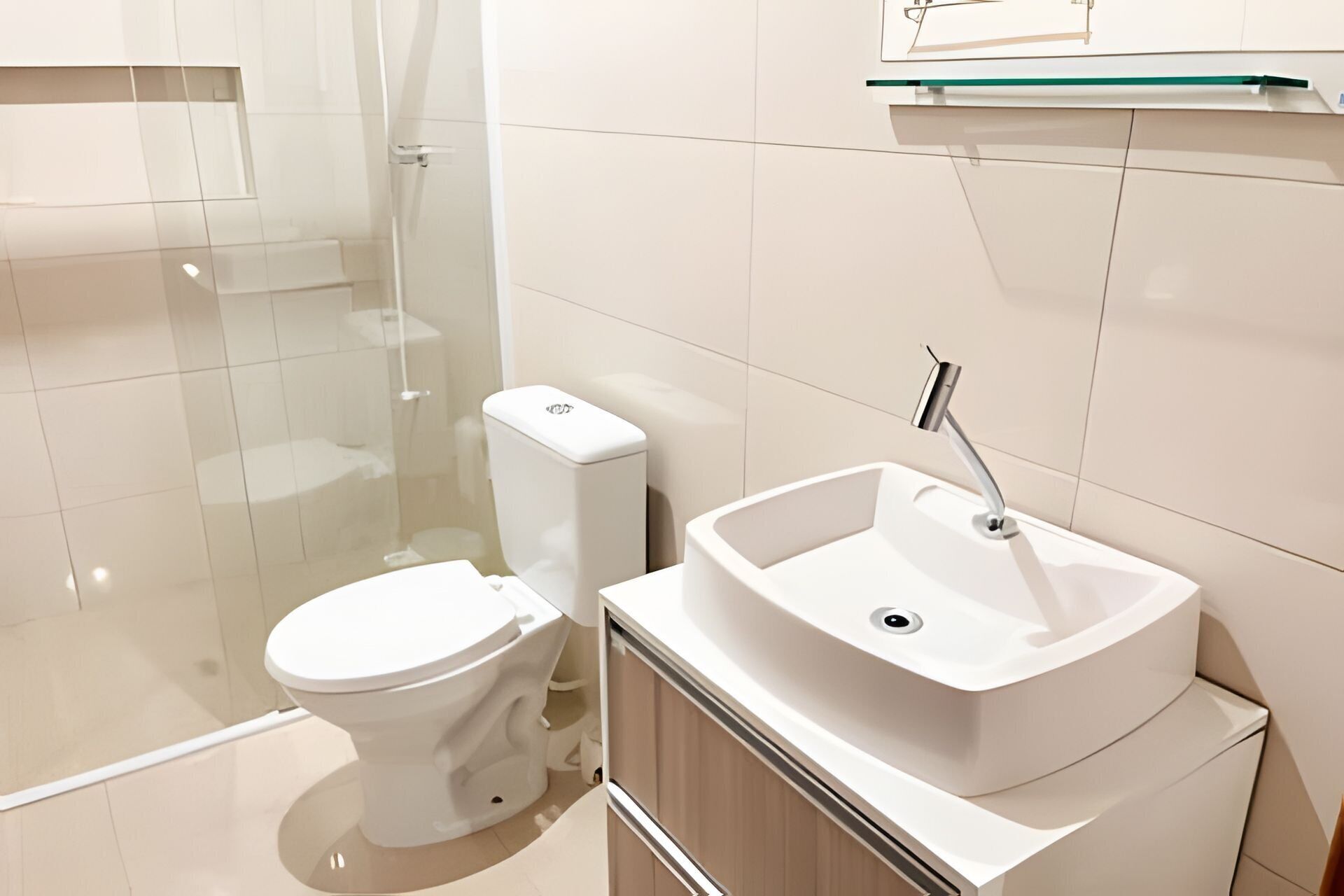 Ein modernes Badezimmer mit Toilette, Waschbecken und Duschkabine.