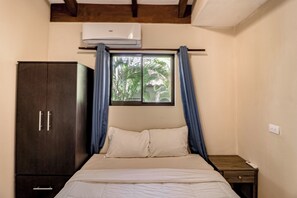 A bedroom with a bed, a wardrobe, a window with curtains, and a bedside table. - Beach Access & Resort Perks: Playa Hermana Villa (Playa Hermosa)