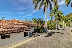 A residential area with a tiled roof house, paved road, and palm trees. - Beach Access & Resort Perks: Playa Hermana Villa (Playa Hermosa)