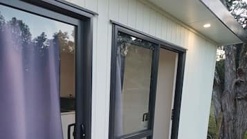 A modern building with large sliding glass doors leading to an outdoor deck.
