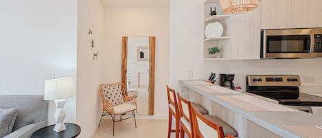 Une cuisine moderne équipée d’un four à micro-ondes, d’une cuisinière et de tabourets de bar.