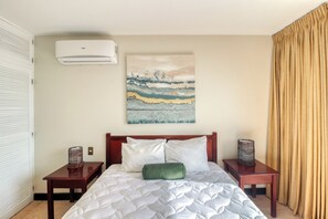A hotel room with a bed, a wall-mounted air conditioner, a painting, and a curtain. - Playa Hermosa Resort Villa w/ Ocean Views & Pool! (Playa Hermosa)