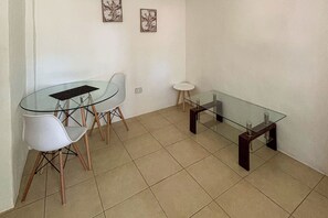 A small dining area with a glass table and chairs, a small round table, and two framed floral artworks on the wall. - Club Voca Studio w/ Resort-Style Pool + Near Beach (Playas del Coco)