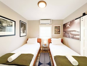 A hotel room with two beds, a small table with a lamp, and artwork on the walls. - Retro Lounge | Family-friendly, Arcade Games+Patio (San Diego)